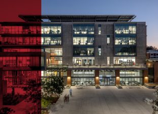 View from the courtyard into the light-filled building at dusk