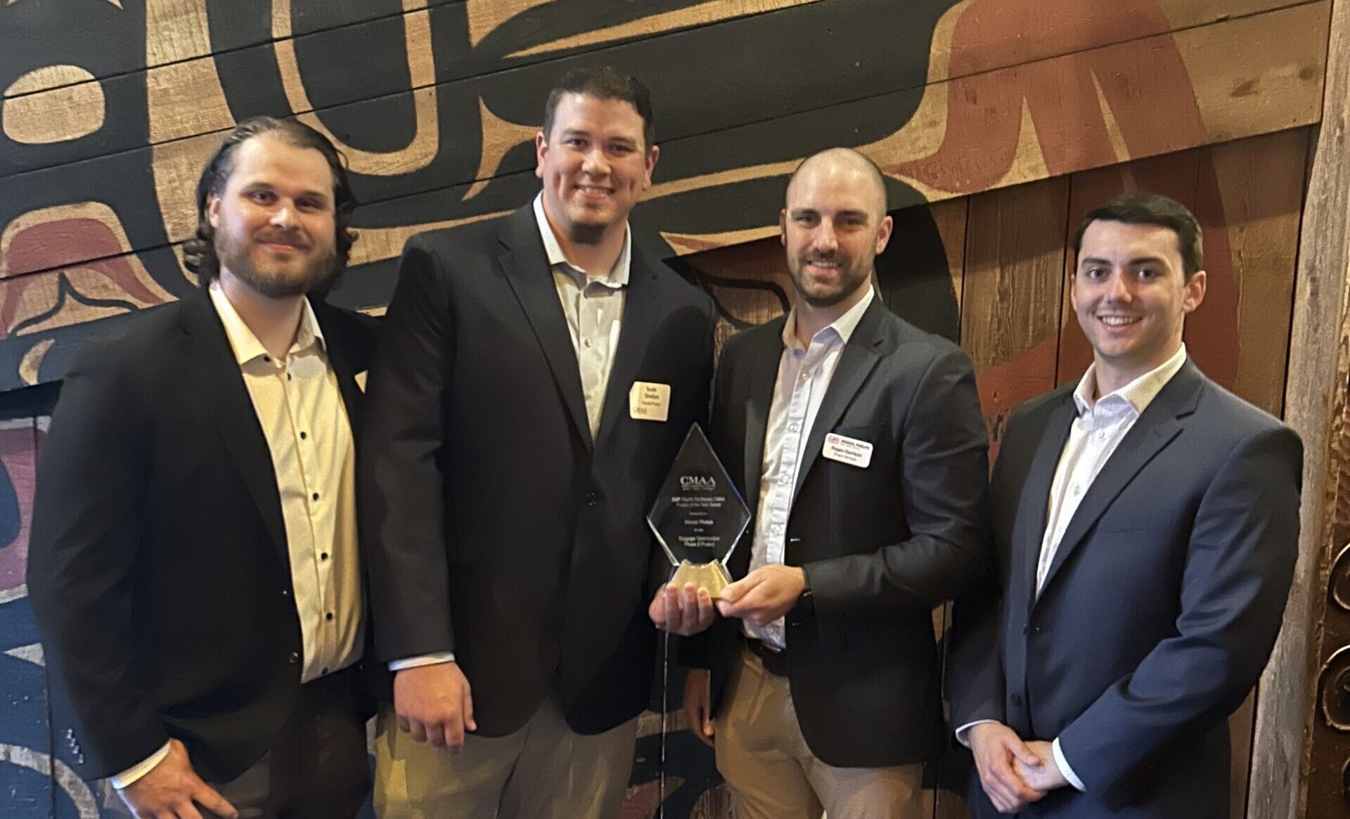 Four individuals holding an award.