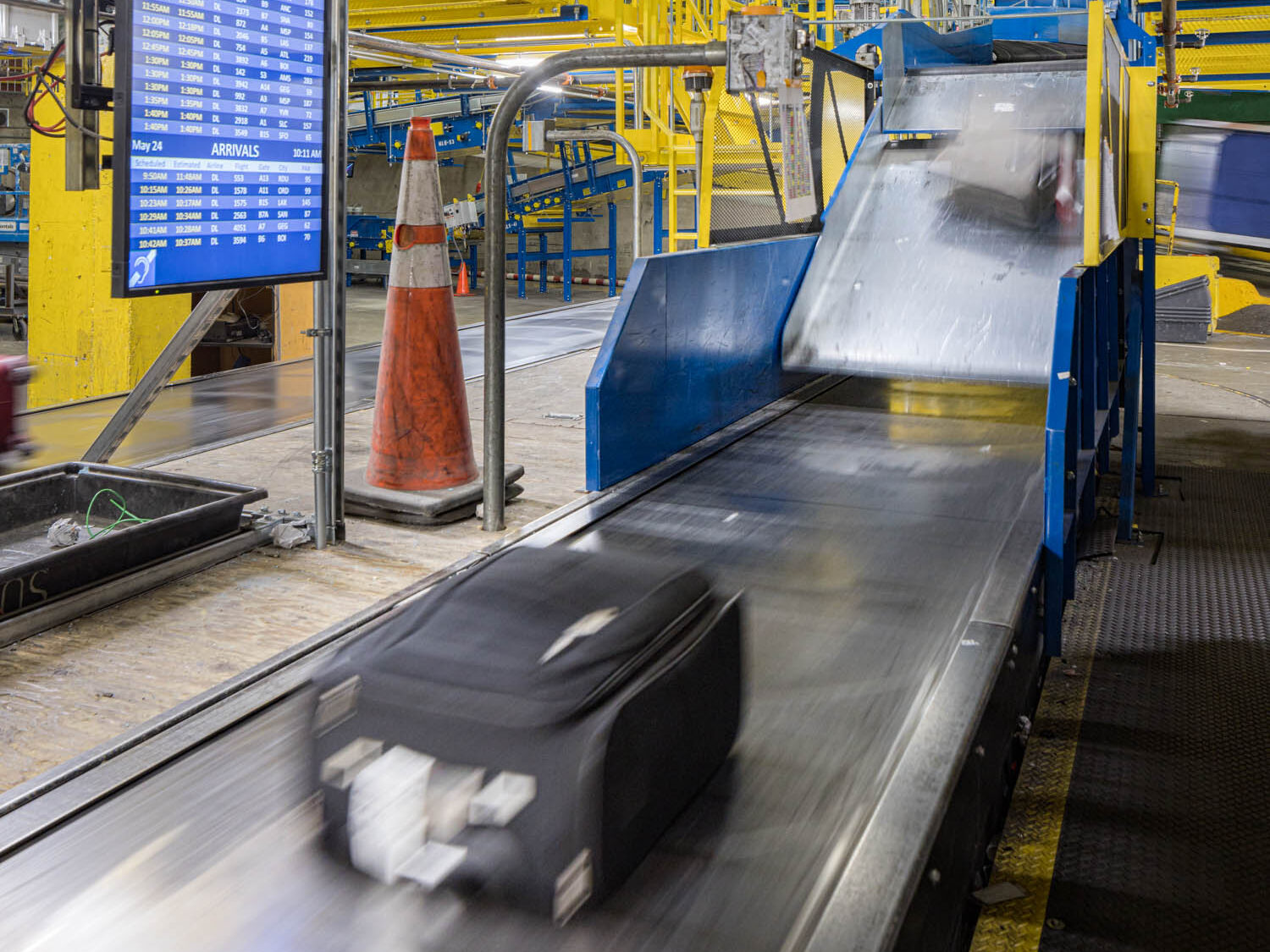 SEA Baggage conveyer belt with luggage sliding through the system. 