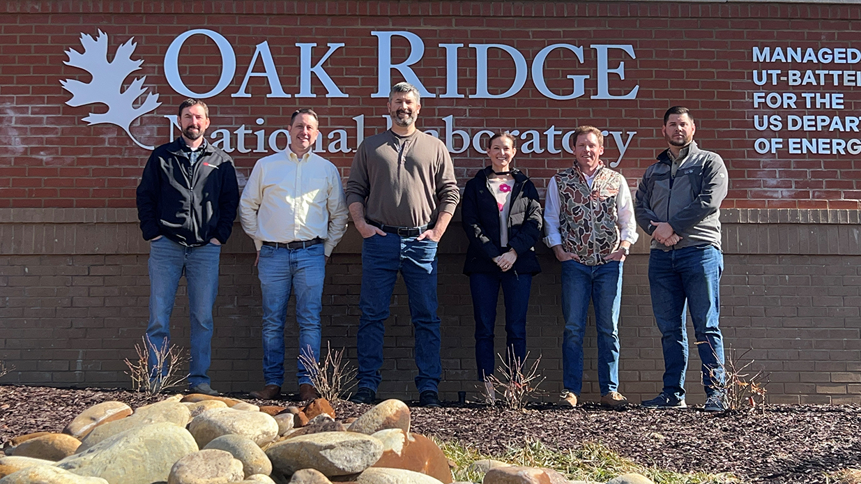 Oak Ridge Project Team stands in front of project sign.