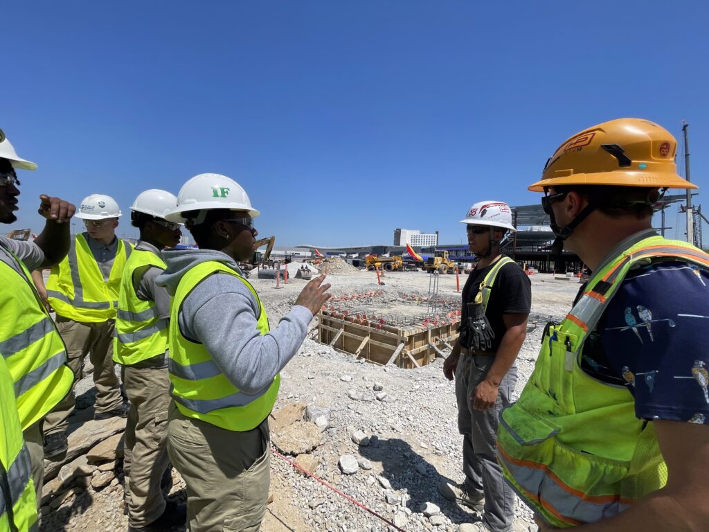 Hensel Phelps team members and project partners stand together at an active construction site.