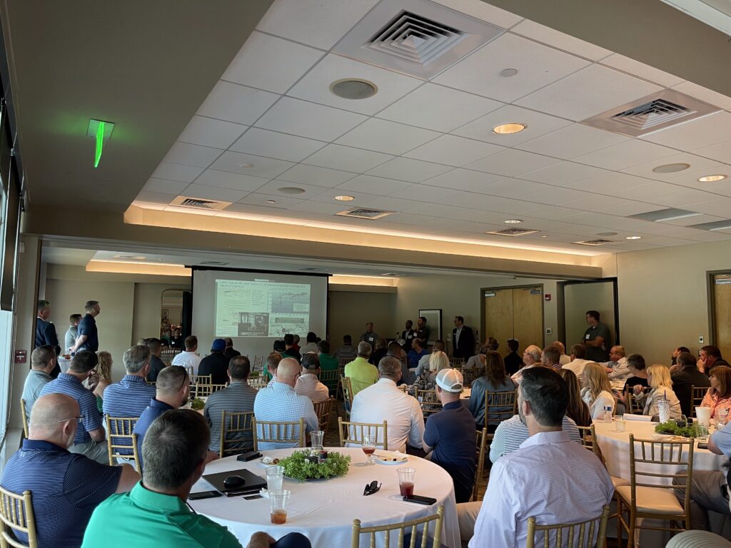 Hensel Phelps team members and industry partners attend a meeting in a conference setting.