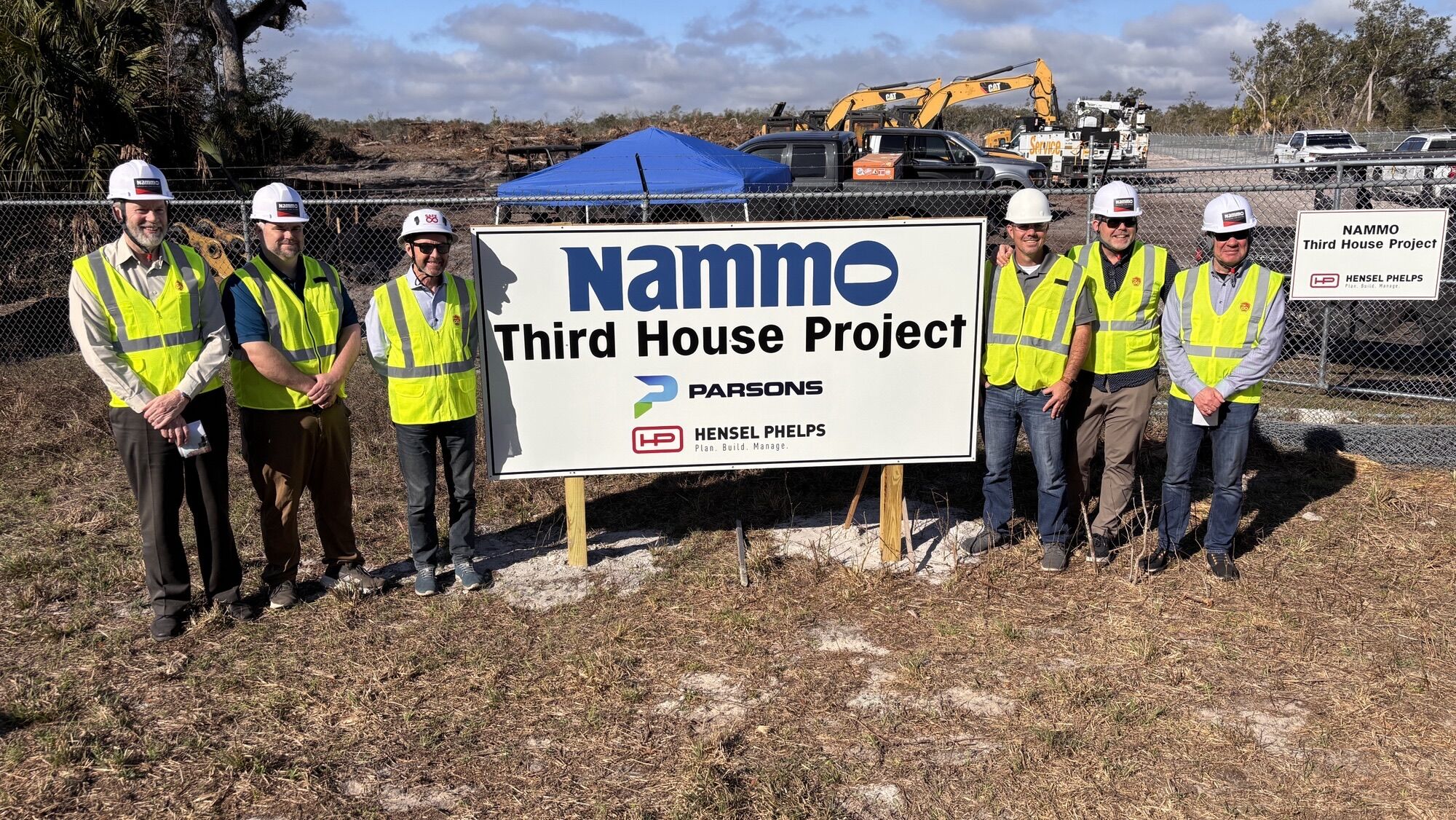 Construction team stands next to NAMMO Third House Project at build site