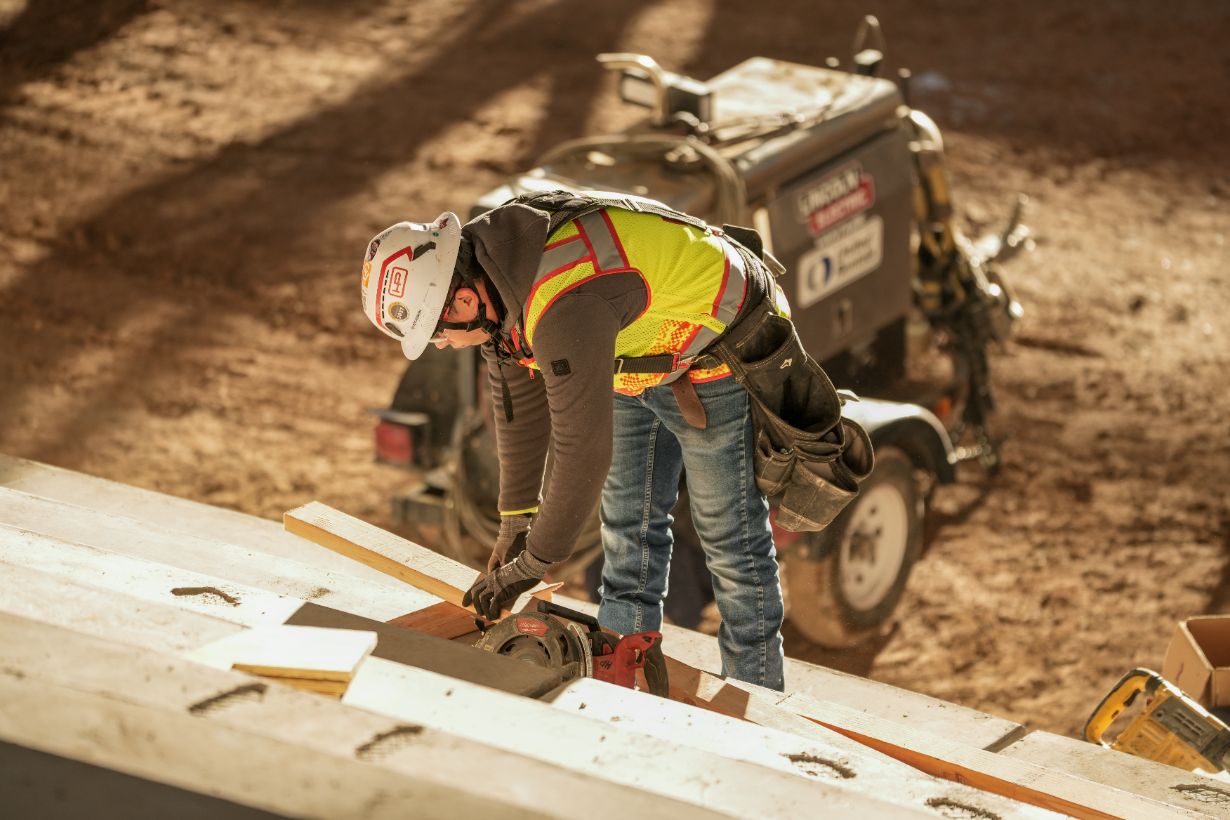 Craft laborer cuts lumber on a construction site