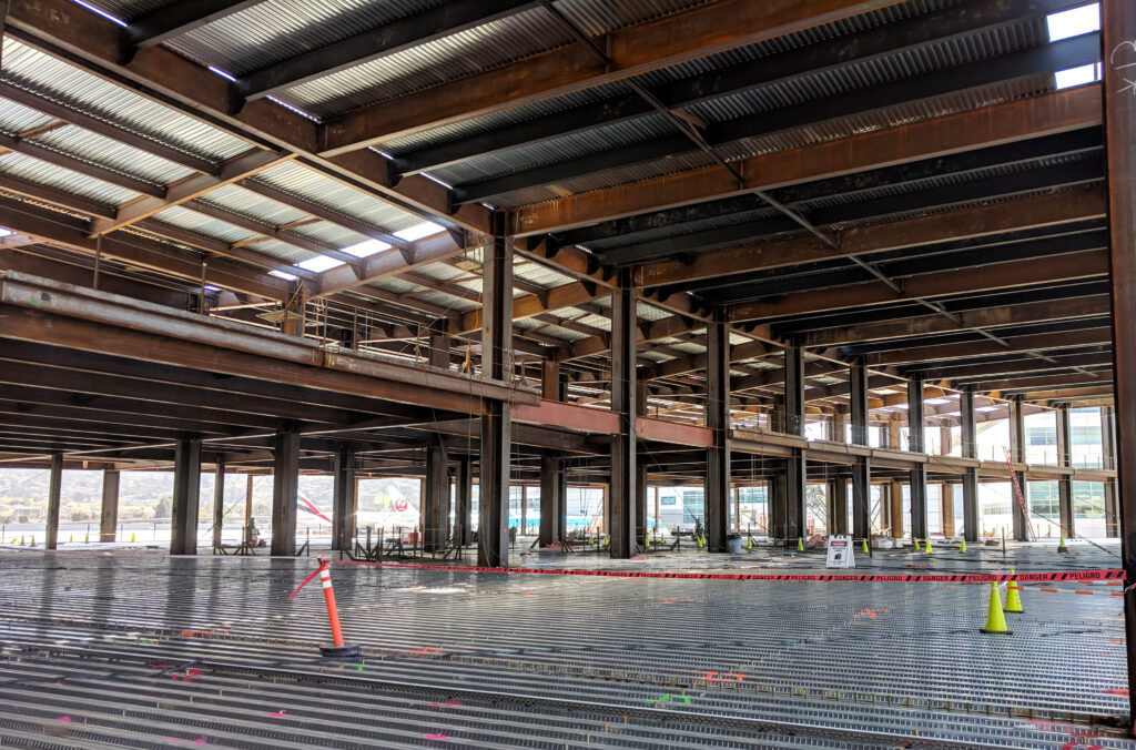 The Harvey Milk Terminal 1 under active construction, showcasing ongoing structural framing.