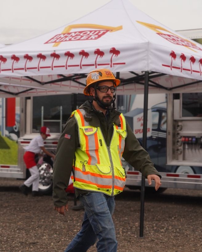 Hensel Phelps construction worker walks past In-N-Out food truck